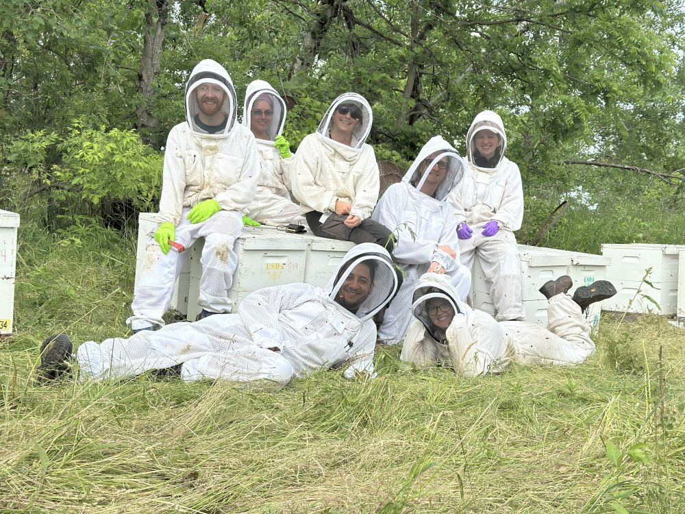 Group of people in bee suits posing for photo